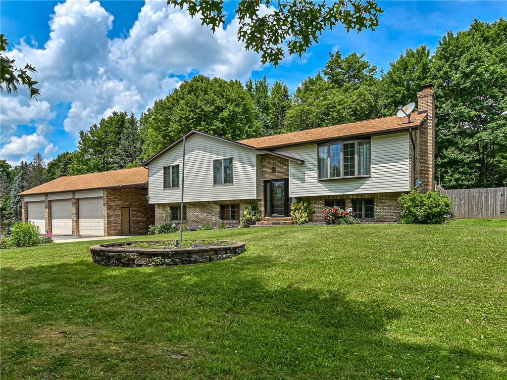 a front view of a house with a yard and trees