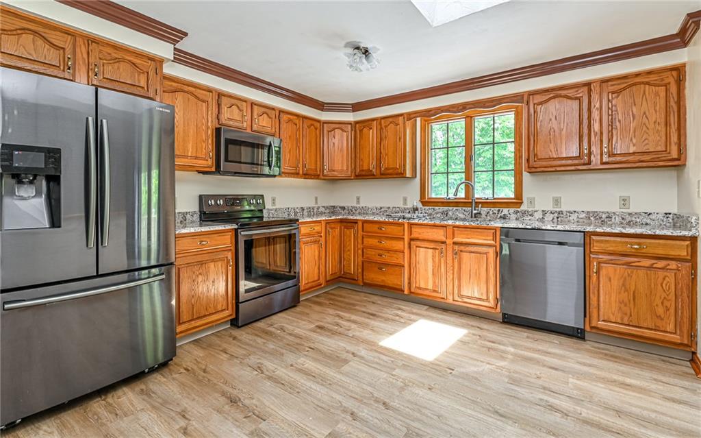 175 Dance Hall Road Apollo, PA 15613 - Photo 12 of 37 a kitchen with stainless steel appliances granite countertop a stove a sink dishwasher a refrigerator and cabinets with wooden floor