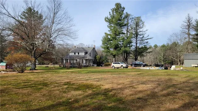 an aerial view of residential houses with outdoor space and trees