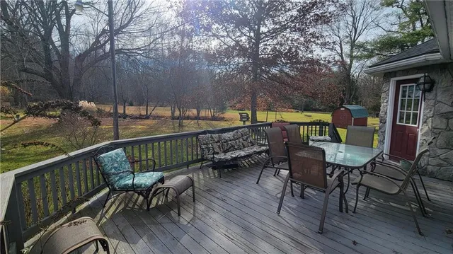 a view of deck with furniture and trees