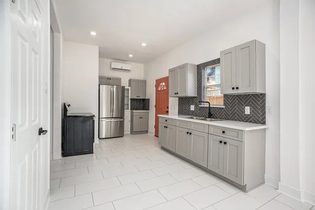 a kitchen with stainless steel appliances granite countertop a refrigerator and a stove top oven