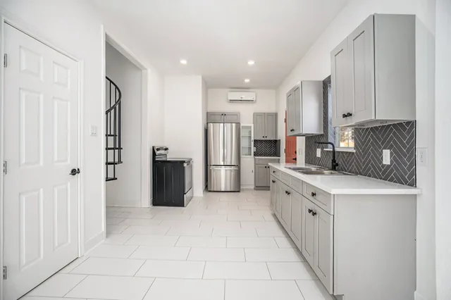 a kitchen with stainless steel appliances granite countertop a refrigerator and a stove