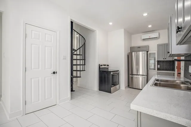 a kitchen with stainless steel appliances a refrigerator and a stove top oven