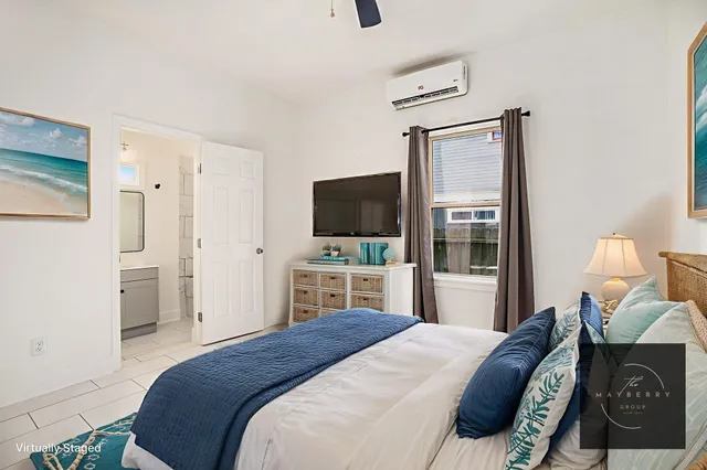 a bedroom with a bed and a flat tv screen on dresser