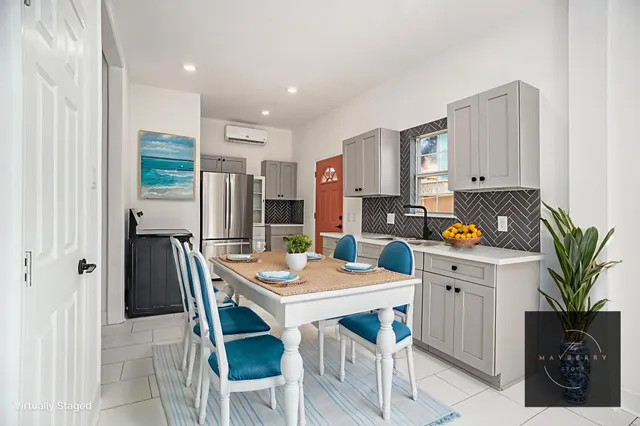 a kitchen with stainless steel appliances a table chairs and a refrigerator