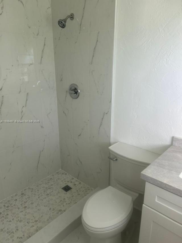 635 Hummingbird Lane Delray Beach, FL 33445 - Photo 12 of 21 a white toilet next to a shower