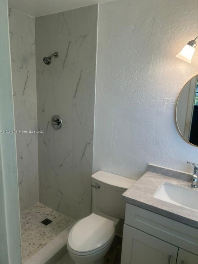 635 Hummingbird Lane Delray Beach, FL 33445 - Photo 13 of 21 a bathroom with a sink a toilet and shower