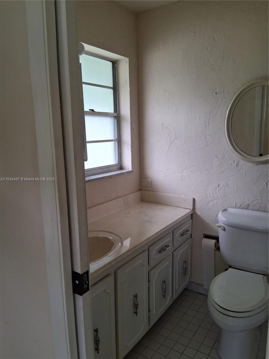 635 Hummingbird Lane Delray Beach, FL 33445 - Photo 16 of 21 a bathroom with a granite countertop toilet sink and mirror