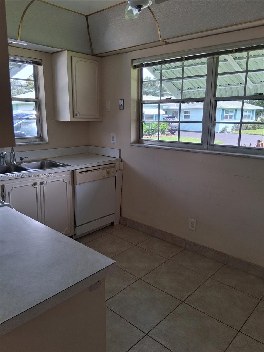 635 Hummingbird Lane Delray Beach, FL 33445 - Photo 6 of 21 a kitchen with a sink a window and cabinets