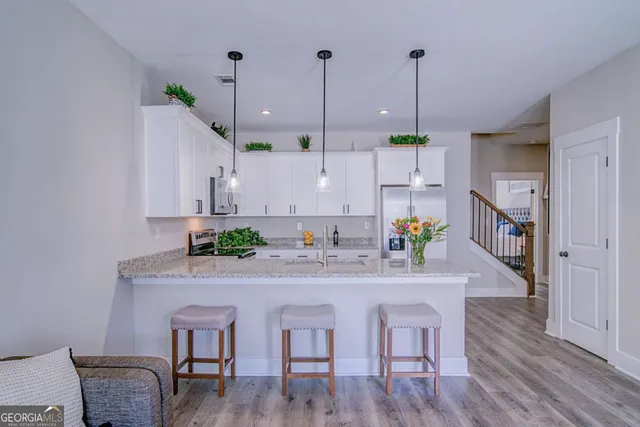 a kitchen with kitchen island a wooden floor and white appliances
