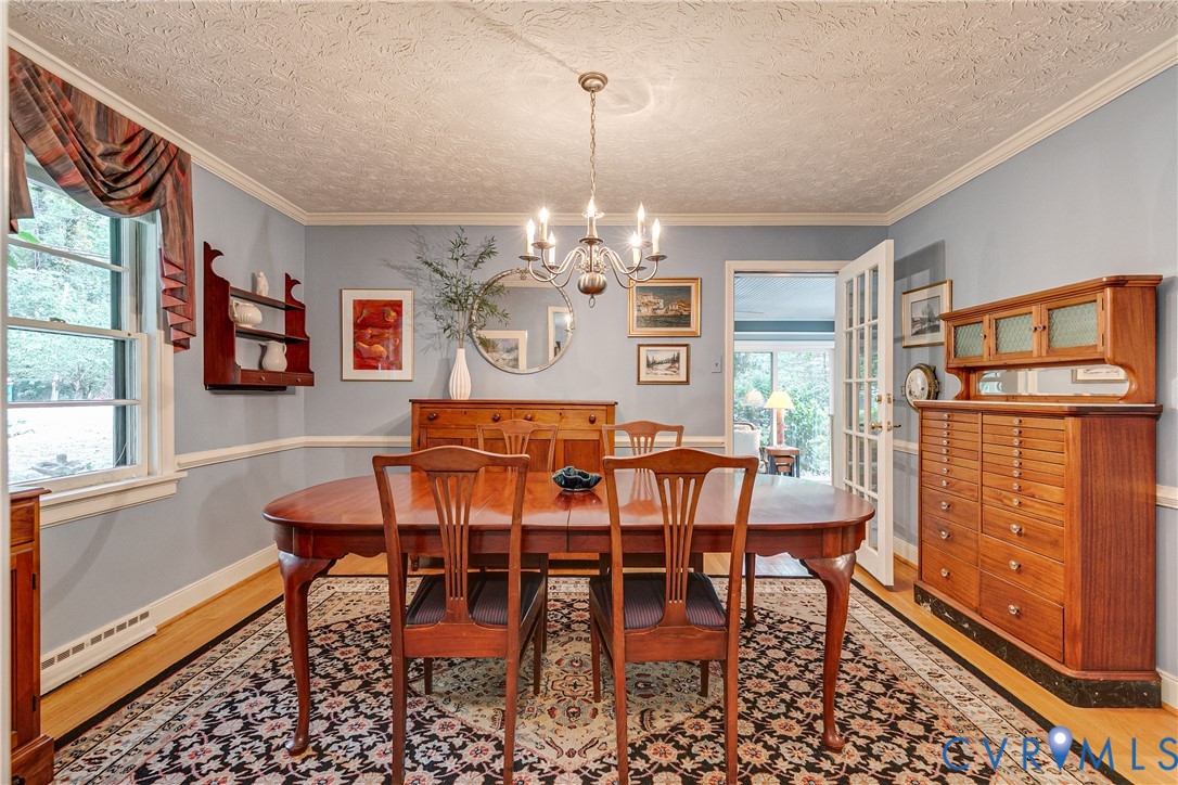 4411 Arrowhead Road Richmond, VA 23235 - Photo 12 of 33 a view of a dining room with furniture a chandelier and wooden floor