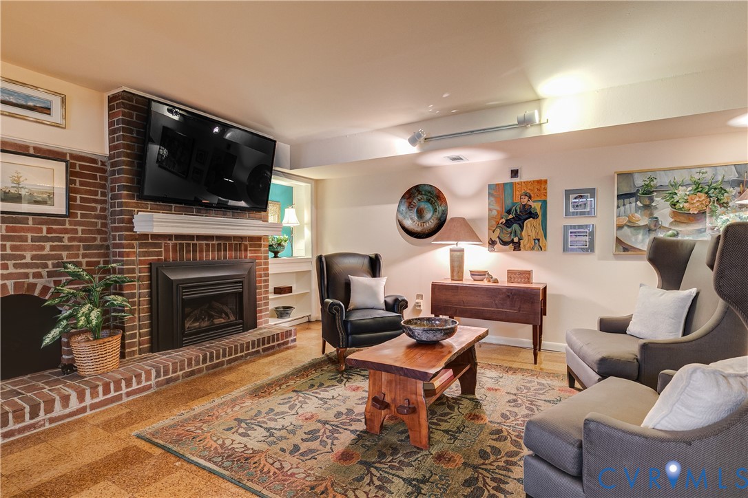 4411 Arrowhead Road Richmond, VA 23235 - Photo 26 of 33 a living room with furniture a flat screen tv and a fireplace