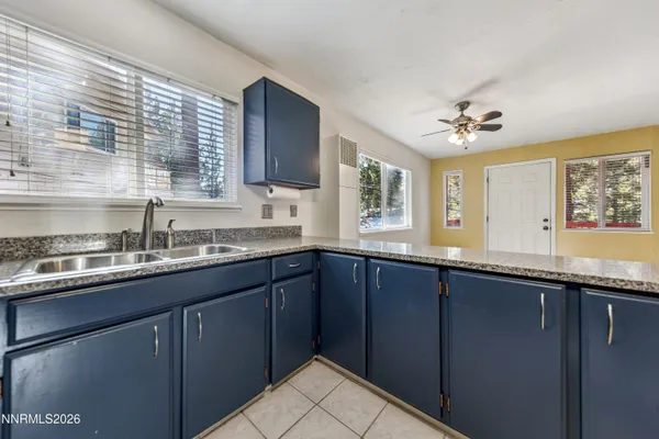 a kitchen with granite countertop a sink stainless steel appliances and cabinets
