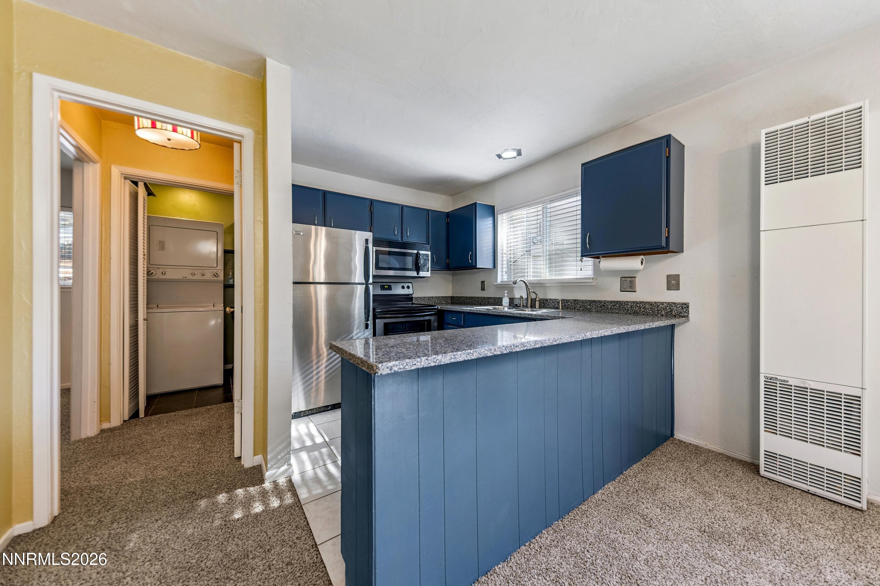 219 South Benjamin Drive, Unit B Stateline, NV 89449 - Photo 5 of 22 a kitchen with stainless steel appliances granite countertop a refrigerator and a sink