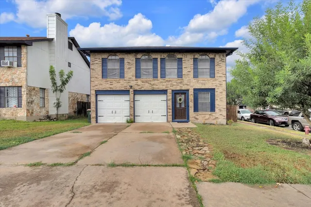 a front view of a house with a garden and yard