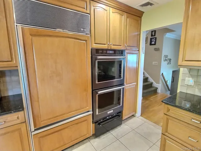 a view of a kitchen with fridge and wooden floor