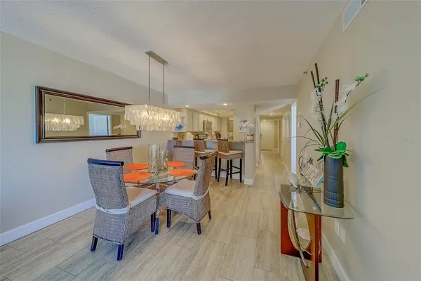 a dining room with furniture a chandelier and wooden floor