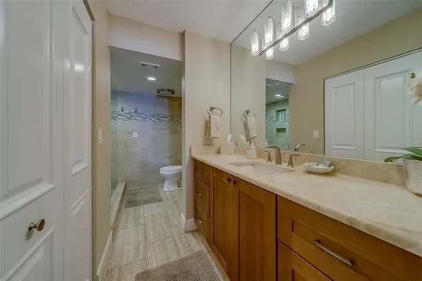 a bathroom with a double vanity sink mirror and shower