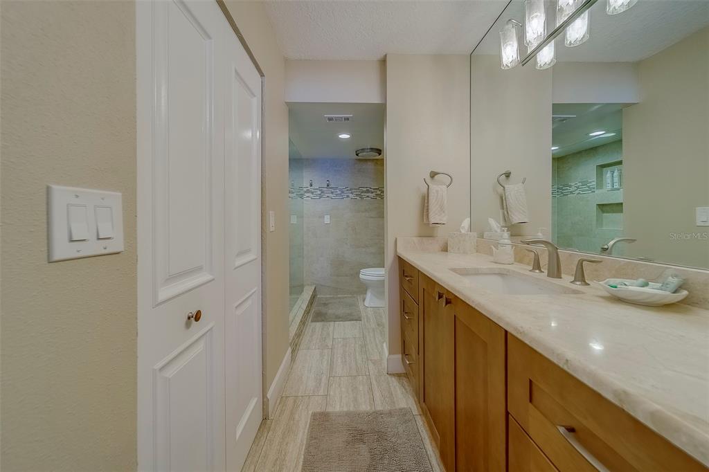 17980 Gulf Boulevard, Unit 402 Redington Shores, FL 33708 - Photo 24 of 63 a bathroom with a double vanity sink mirror and shower