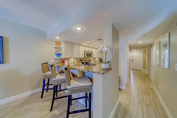 a kitchen that has a lot of cabinets and wooden floor