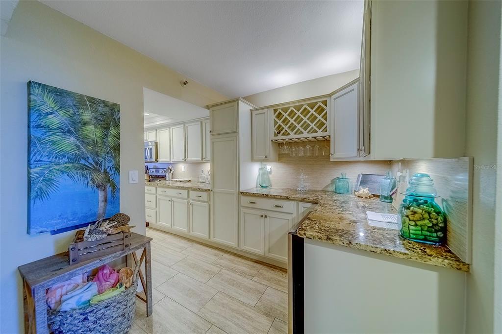 17980 Gulf Boulevard, Unit 402 Redington Shores, FL 33708 - Photo 6 of 63 a kitchen that has a lot of cabinets and wooden floor