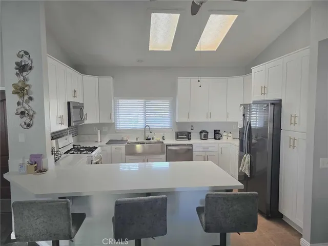 a kitchen with a dining table chairs and a refrigerator
