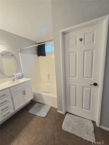 a room with a bed and a double vanity sink