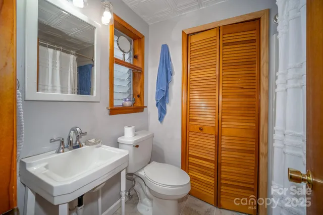 a bathroom with a sink a toilet and a mirror