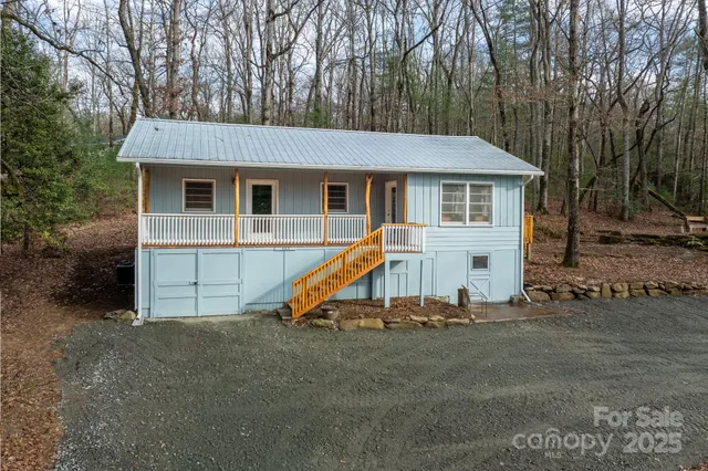 a view of a house with a yard and wooden fence