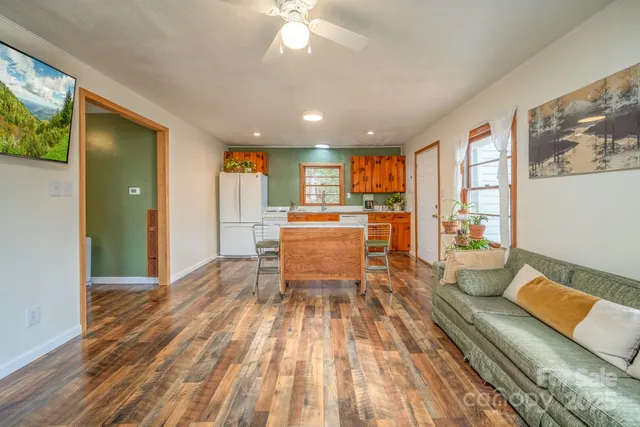 a open kitchen with stainless steel appliances granite countertop a refrigerator oven stove a dining table and chairs with wooden floor