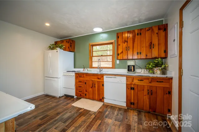 a kitchen with stainless steel appliances granite countertop a refrigerator sink and wooden cabinets