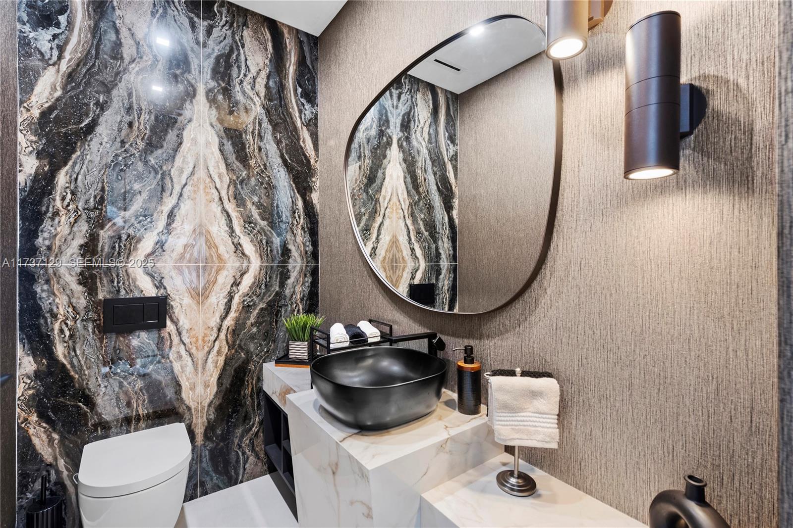 1785 Cleveland Road Miami Beach, FL 33141 - Photo 35 of 67 a bathroom with a toilet sink and mirror