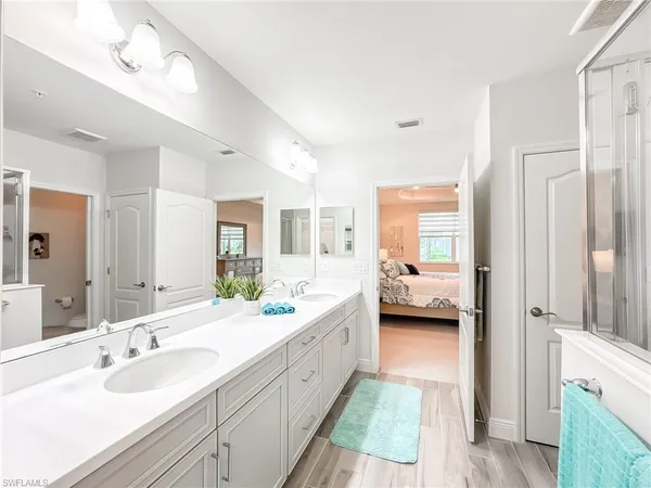 a en suite bathroom with a double vanity sink a mirror and a shower