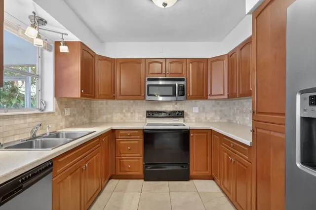 a kitchen with stainless steel appliances granite countertop a sink stove and microwave