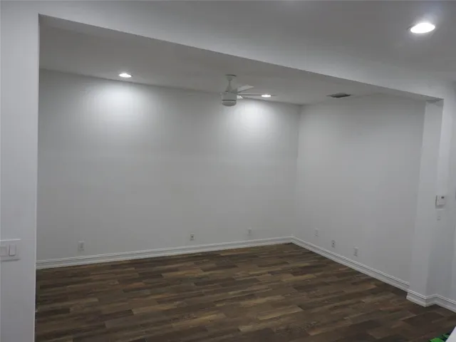 a view of an empty room with wooden floor and closet