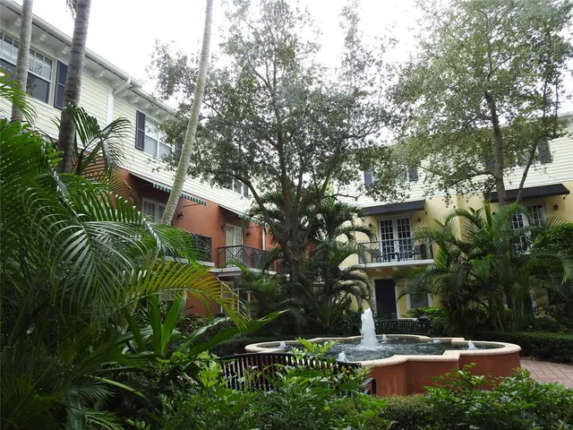 a view of a building with a yard and plants