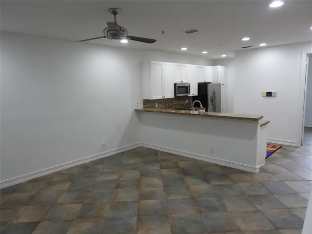 a view of a kitchen with a sink and a ceiling fan