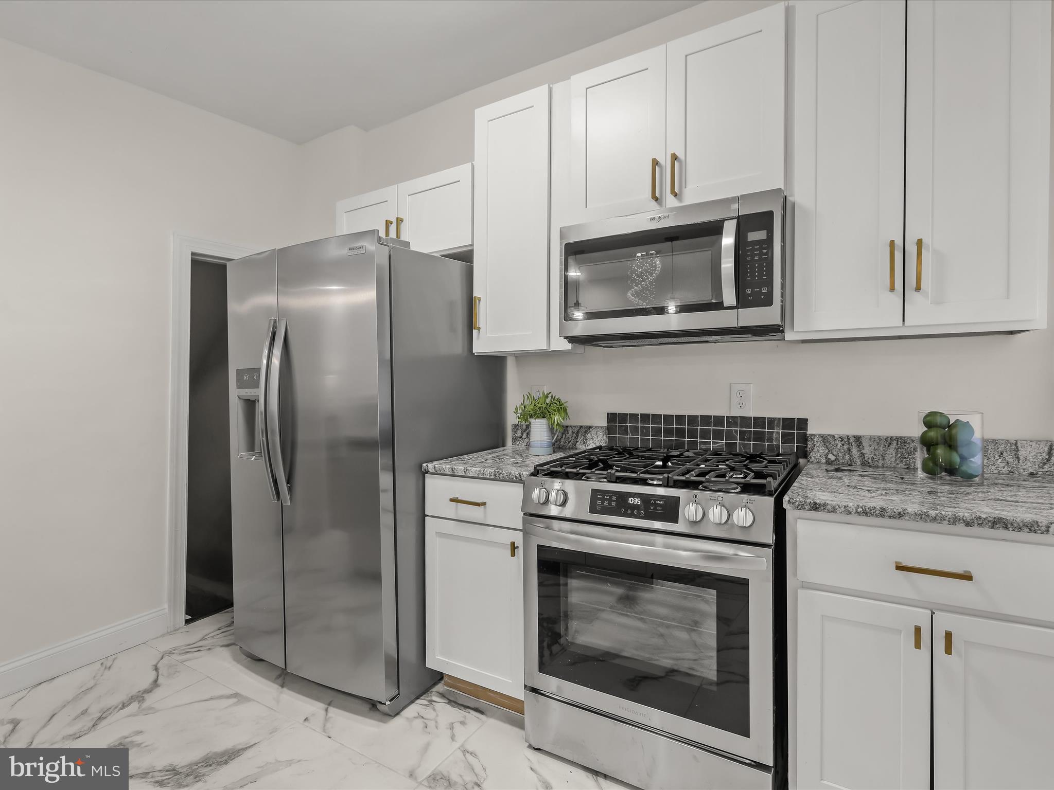 732 Edgewood Street Baltimore, MD 21229 - Photo 14 of 41 a kitchen with stainless steel appliances granite countertop white cabinets a refrigerator and a stove top oven