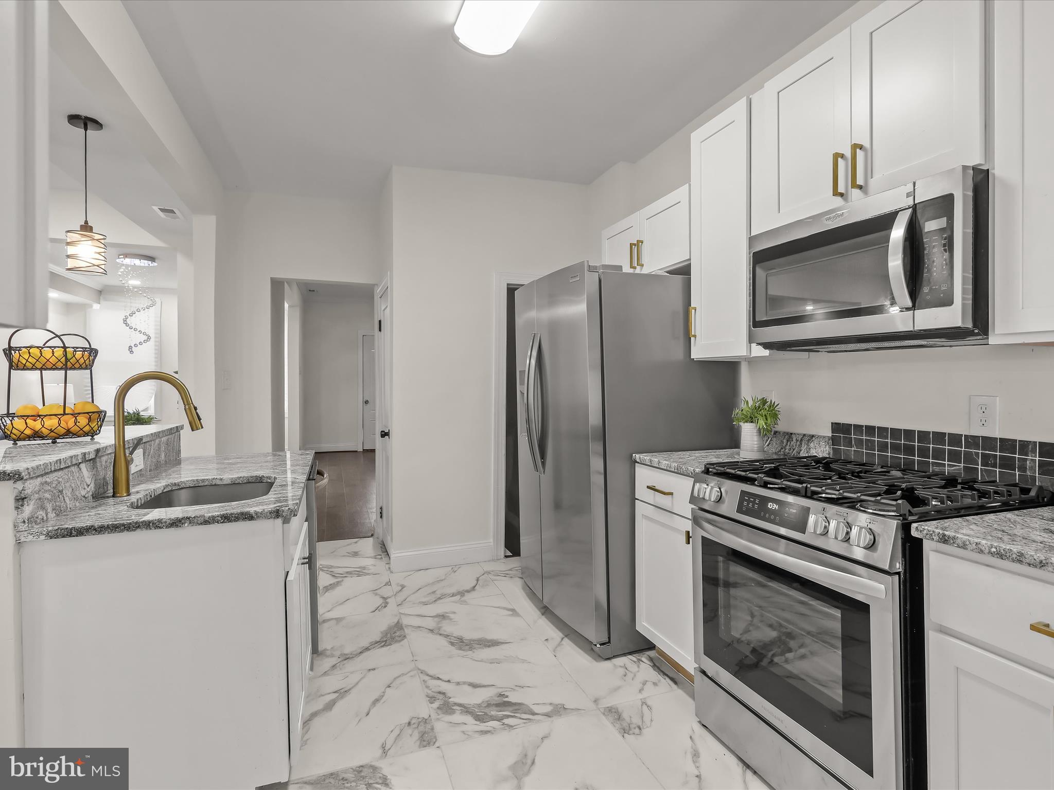 732 Edgewood Street Baltimore, MD 21229 - Photo 16 of 41 a kitchen with stainless steel appliances granite countertop a stove a sink and a microwave