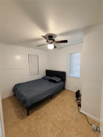 a living room with a bed furniture and a ceiling fan