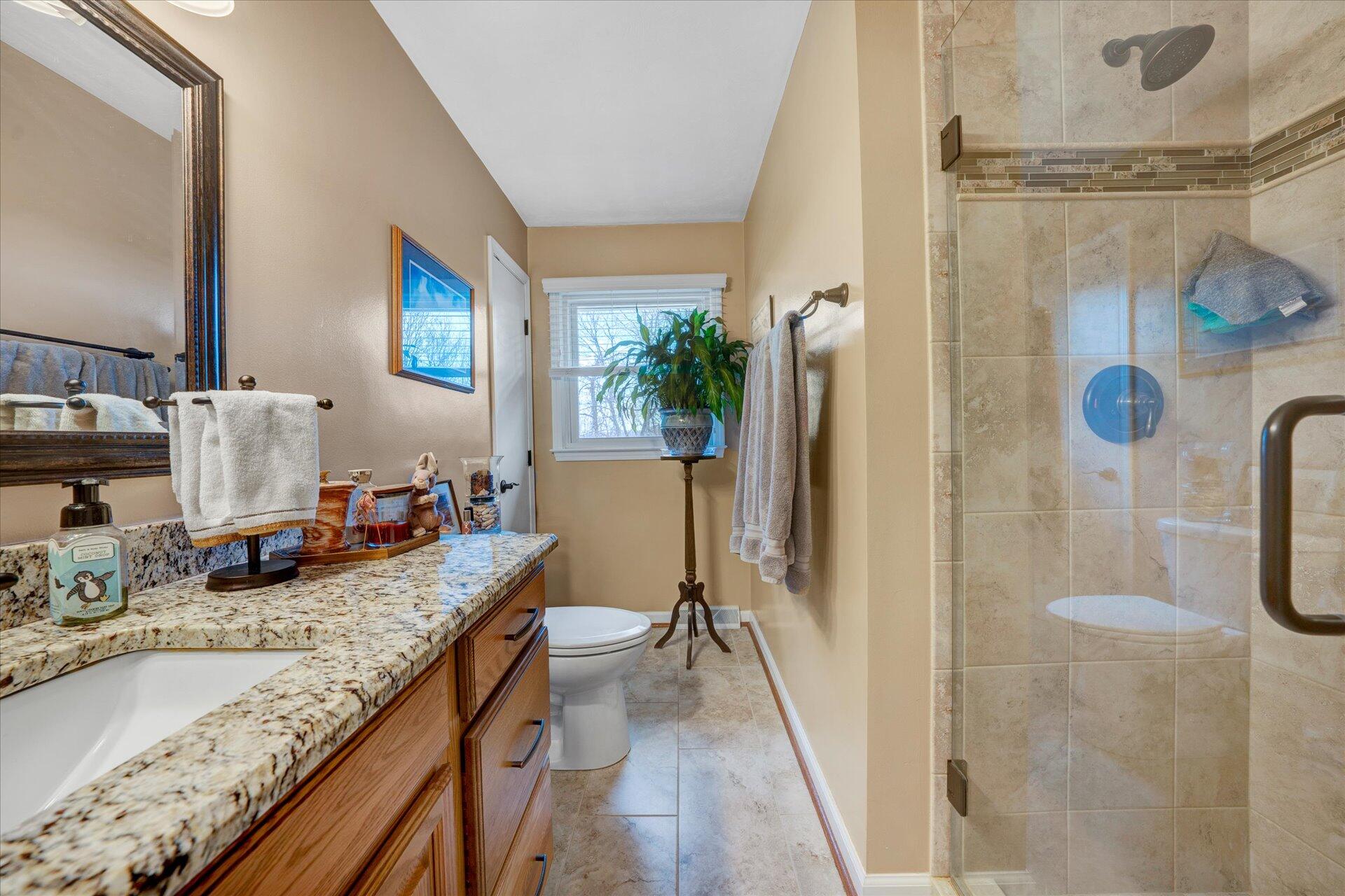111 Deep Dell Road Salem, VA 24153 - Photo 10 of 39 a bathroom with a granite countertop sink a mirror a vanity and shower