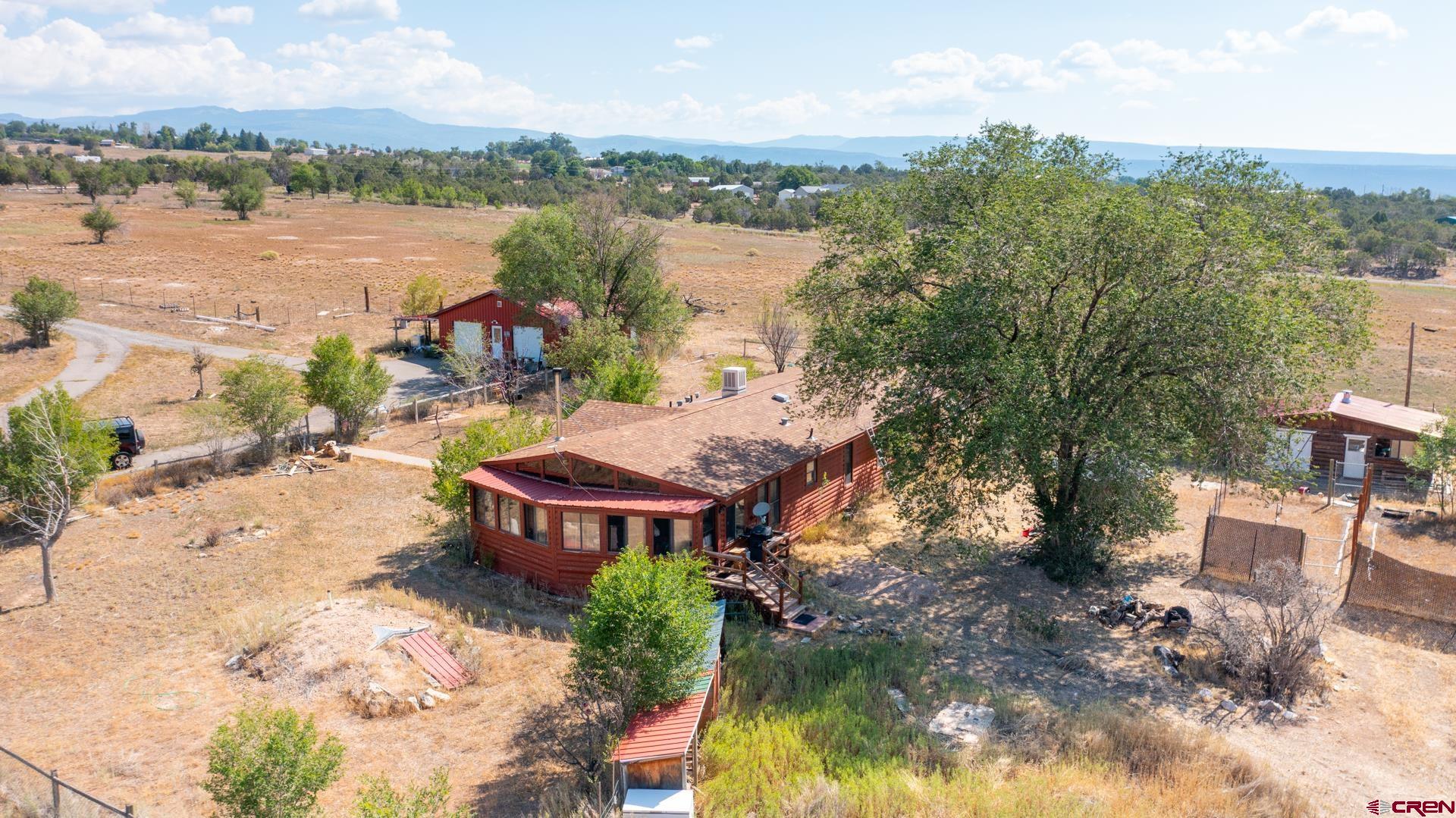 25186 Cedar Mesa Road Cedaredge, CO 81413 - Photo 8 of 17 an aerial view of a house with lake view and a mountain view in back
