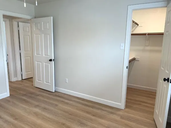an empty room with wooden floor and closet