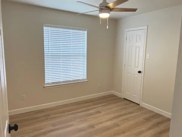 an empty room with a window and wooden floor