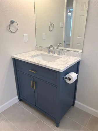 a bathroom with a granite countertop sink and a mirror