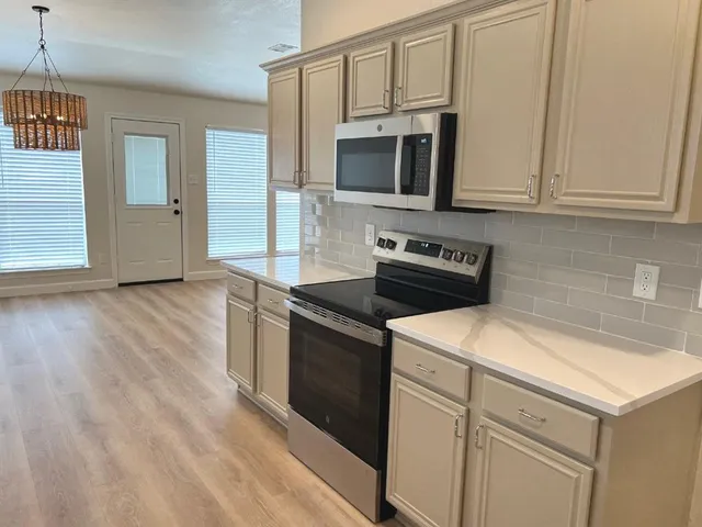 a kitchen with stainless steel appliances granite countertop a stove and a microwave