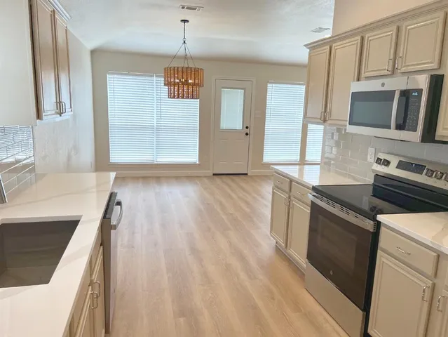 a kitchen with stainless steel appliances granite countertop a sink stove and refrigerator