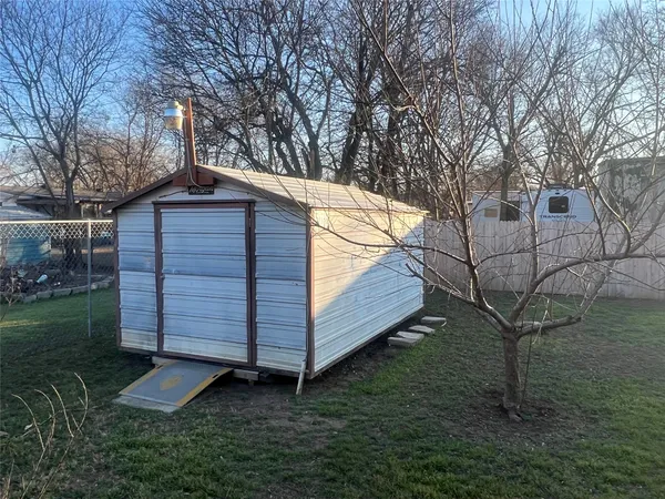 a view of backyard with wooden fence and a large tree