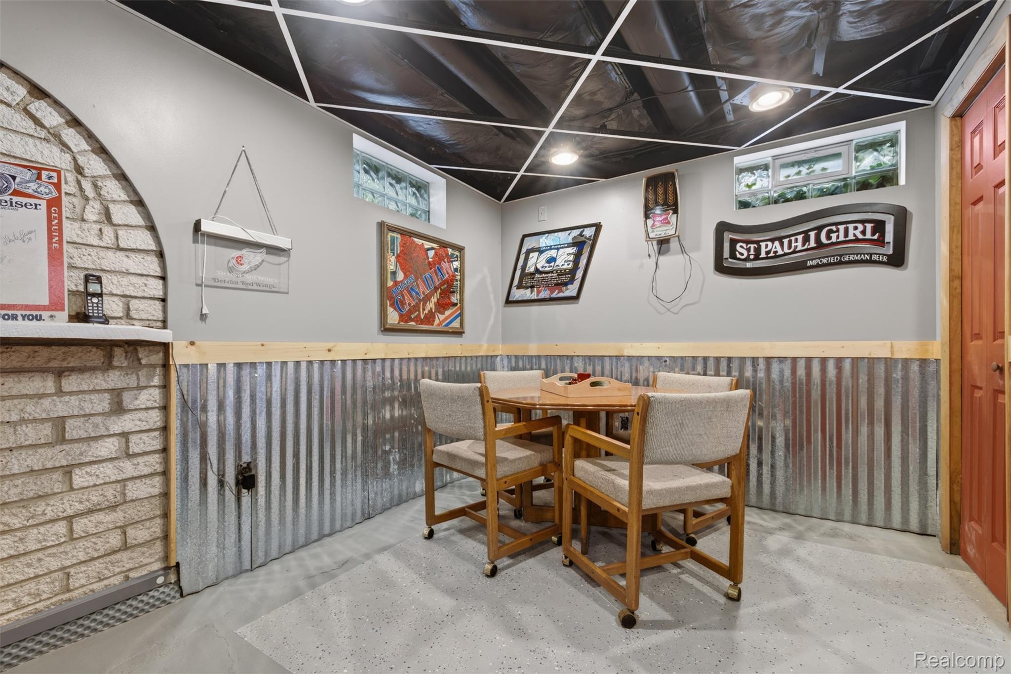 5977 Anglers Road Ortonville, MI 48462 - Photo 27 of 63 Finished recreational space featuring corrugated metal wainscoting, light gray painted walls, and an arched brick-finish accent wall