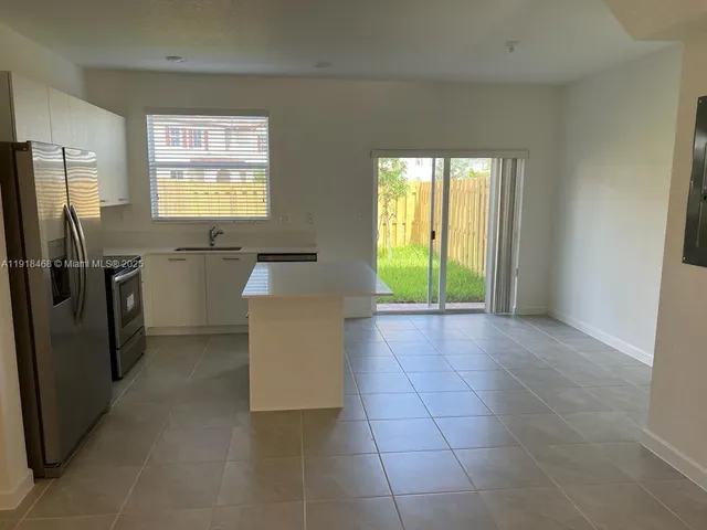 a kitchen with granite countertop a sink a stove top oven and stainless steel appliances